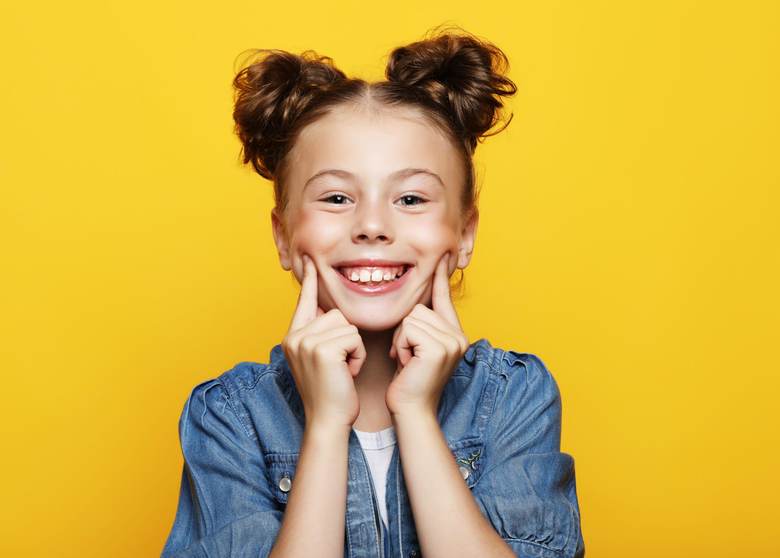 emotion, childhood and people concept: Portrait of cheerful smiling little girl on yellow background
